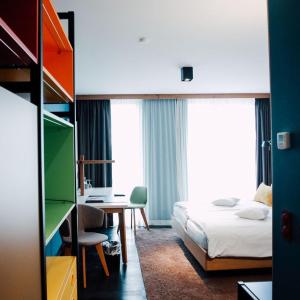 波鸿克劳狄斯酒店 的酒店客房带一张床铺、一张书桌和一间卧室