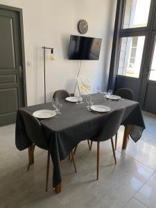 沙布利Le Merrain gîte plein coeur de Chablis的一张桌子,上面有椅子和一张黑色的桌布