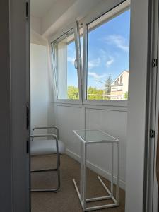 林茨Appartement Lena的客房设有桌子、椅子和窗户。