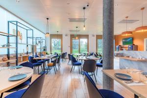 日内瓦Appart'City Collection Genève Aéroport - Vernier的用餐室设有桌椅和窗户。