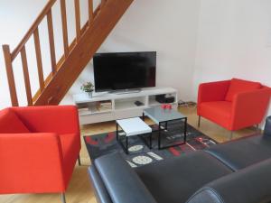 斯特拉斯堡奥奎德斯皮切尔斯公寓的客厅配有2把红色椅子和平面电视