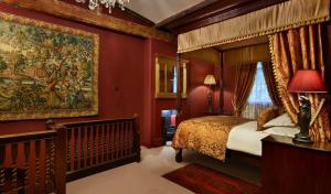伦敦鲁克里酒店的一间卧室设有一张天蓬床和一个大挂毯。