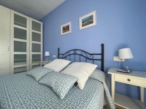 隆达Apartamento Alameda del Tajo III Centro Parquing的蓝色卧室配有一张床和一张书桌
