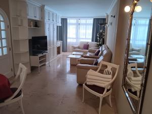 英格兰海滩Club Excelsior II的客厅配有沙发、椅子和镜子