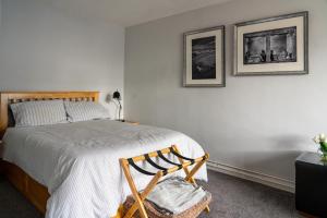 伯纳姆Nr WINDSOR stunning 1 bedroom self contained property in Burnham near Heathrow的卧室配有一张床,墙上挂有两张照片
