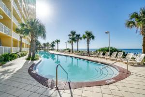 巴拿马城海滩Calypso Beach Resort & Towers by Panhandle Getaways的一个带椅子的游泳池,背景是大海