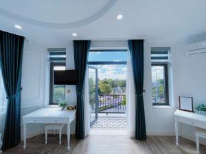 永隆Paris Hotel & Cafe的带2张桌子的客房和窗户的阳台
