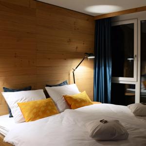 波鸿克劳狄斯酒店 的卧室配有一张带黄色枕头的大型白色床。