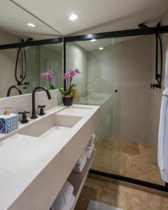 帕拉蒂Sandi Hotel的一间带水槽和淋浴的浴室