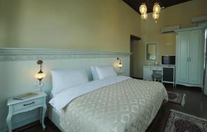 伯萨布尔萨依皮佑鲁住宿加早餐旅馆的卧室配有一张白色大床和一张书桌
