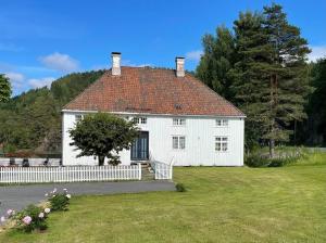 里瑟尔Bosvik Gård, nyrenovert leilighet i hovedhus fra 1756的院子内白色的房屋