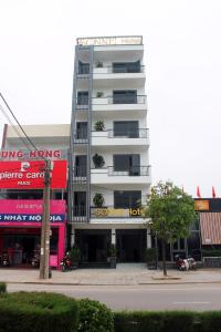 Ðộng HỏiSonne Hotel Quang Binh的一条城市街道上高大的白色建筑