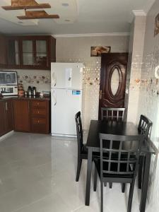 Appartement tarik的厨房配有黑桌和白色冰箱。