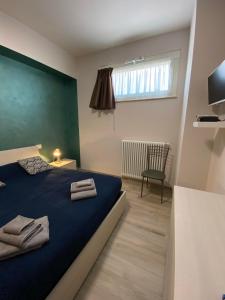 阿尼奥内B&B Tirassegno的一间卧室配有蓝色的床和毛巾