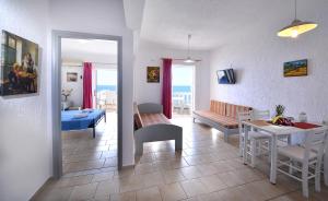 赫索尼索斯阿伦海滩公寓式酒店的一间带桌子的客厅和一间餐厅