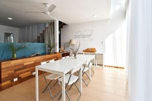马尔格莱特德玛CASA MOOREA的白色的用餐室配有白色的桌椅