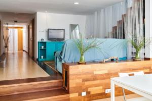 马尔格莱特德玛CASA MOOREA的客厅配有蓝色的沙发和电视
