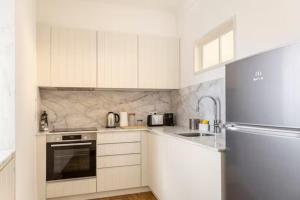 萨尔堡Charming apartment by the river的厨房配有白色橱柜和不锈钢冰箱