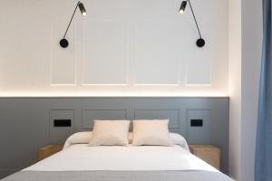 埃尔瓦La Antigua Farmacia的卧室配有白色的床和2个枕头