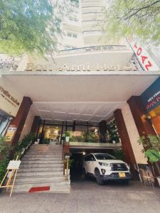 胡志明市Bon Ami Hotel - Thiên Xuân Hotel的停在大楼前的白色汽车