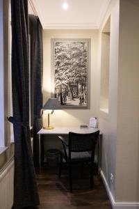 巴特皮尔蒙特Rein Klassik Hotel的客房设有一张桌子、一把椅子和一幅画