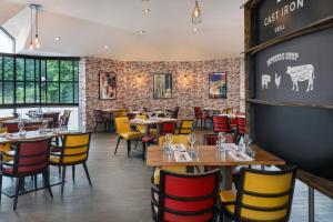 泰恩河畔纽卡斯尔Delta Hotels by Marriott Newcastle Gateshead的餐厅设有木桌和黄色及红色椅子