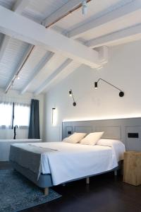 埃尔瓦La Antigua Farmacia的白色卧室设有一张大床和一个浴缸