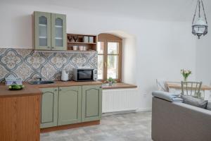 西格利盖特Berkenyeliget Vendégház的一间厨房,内设绿色橱柜和一张沙发