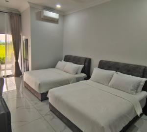 Permatang PauhPaddy Villea Inn SPT Penang的酒店客房设有两张床和窗户。