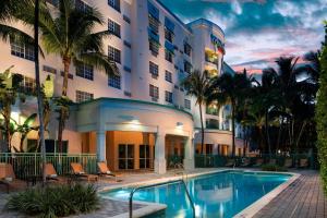 达尼亚滩Courtyard by Marriott Fort Lauderdale Airport & Cruise Port的大楼前设有游泳池的酒店