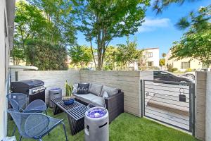 洛杉矶Beverly Grove Chic City Oasis 2 BR Apt with Den 138的一个带烧烤架和桌椅的庭院