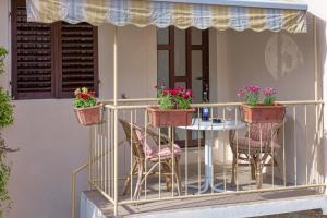 斯塔里格勒Guesthouse Wish的阳台配有桌椅和鲜花。