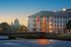 戈尔韦Leonardo Hotel Galway - Formerly Jurys Inn的一座建筑物前的河上桥梁