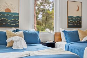 布雷登顿Private Heated Pool - Arcade - Pets - 2 King Beds的客房设有2张蓝色的床和窗户。