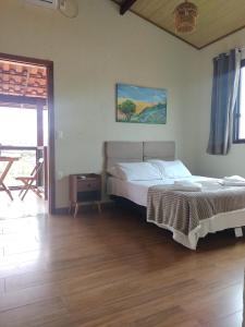 西波山Pousada Mangaba da Serra的一间卧室配有一张床,铺有木地板