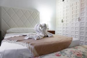 昆卡Complejo Rural Victory的一张带两个天鹅的睡床,用白色毛巾包裹