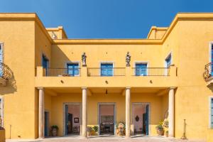 陶尔米纳Casa Cuseni, Patrimonio Culturale Immateriale UNESCO的黄色的建筑,上面设有阳台
