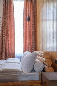 克瓦雷利Hotel Piano Kvareli的卧室配有带枕头的床铺和窗户。