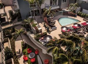 洛杉矶Fairfax District Chic City Oasis 2 BR Apt with Den 136的享有酒店顶部的景色,设有游泳池和棕榈树