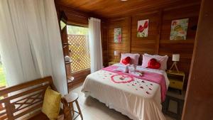 维奥康德马奥Pedacinho de Chão Chalés的一间卧室配有一张带红色枕头的大床