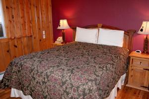 埃斯蒂斯帕克Timber Creek Chalets- 10A chalet的一间卧室配有一张床和紫色的墙壁