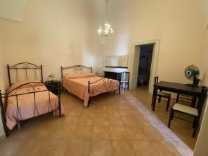 San Pietro in LamaCasa del Nonno Toto的一间卧室配有两张床、一张桌子和一张书桌