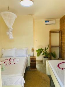 江比阿Jambiani Backpackers Hostel的一间卧室配有两张床和吊灯。