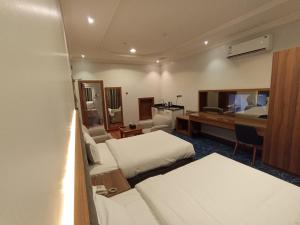 利雅德الماسم للأجنحة المخدومة- الملك فهد的酒店客房配有两张床和一张书桌
