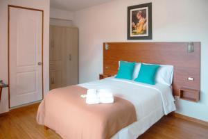 奥克萨潘帕La Posada D'Benjamín的一间卧室配有一张大床和两条毛巾