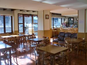 埃斯卡洛纳阿纳尔酒店的一间带桌椅的餐厅和一间酒吧