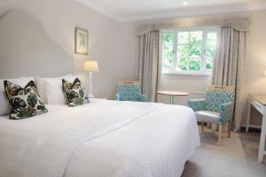 奥萨格Manor House Hotel & Spa, Alsager的卧室配有一张白色大床和椅子