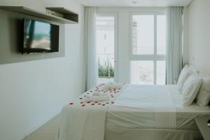 马塞约Wave Suítes Hotel & Lounge bar的一间白色卧室,配有一张红色玫瑰床