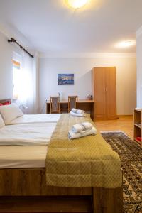 萨拉热窝Guesthouse Rose的一间卧室配有一张大床和毛巾