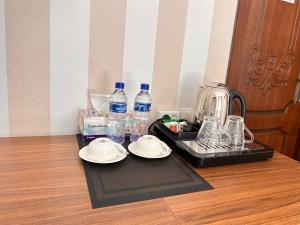 撒马尔罕伊斯宏奇酒店的桌子上装有盘子和水瓶的托盘